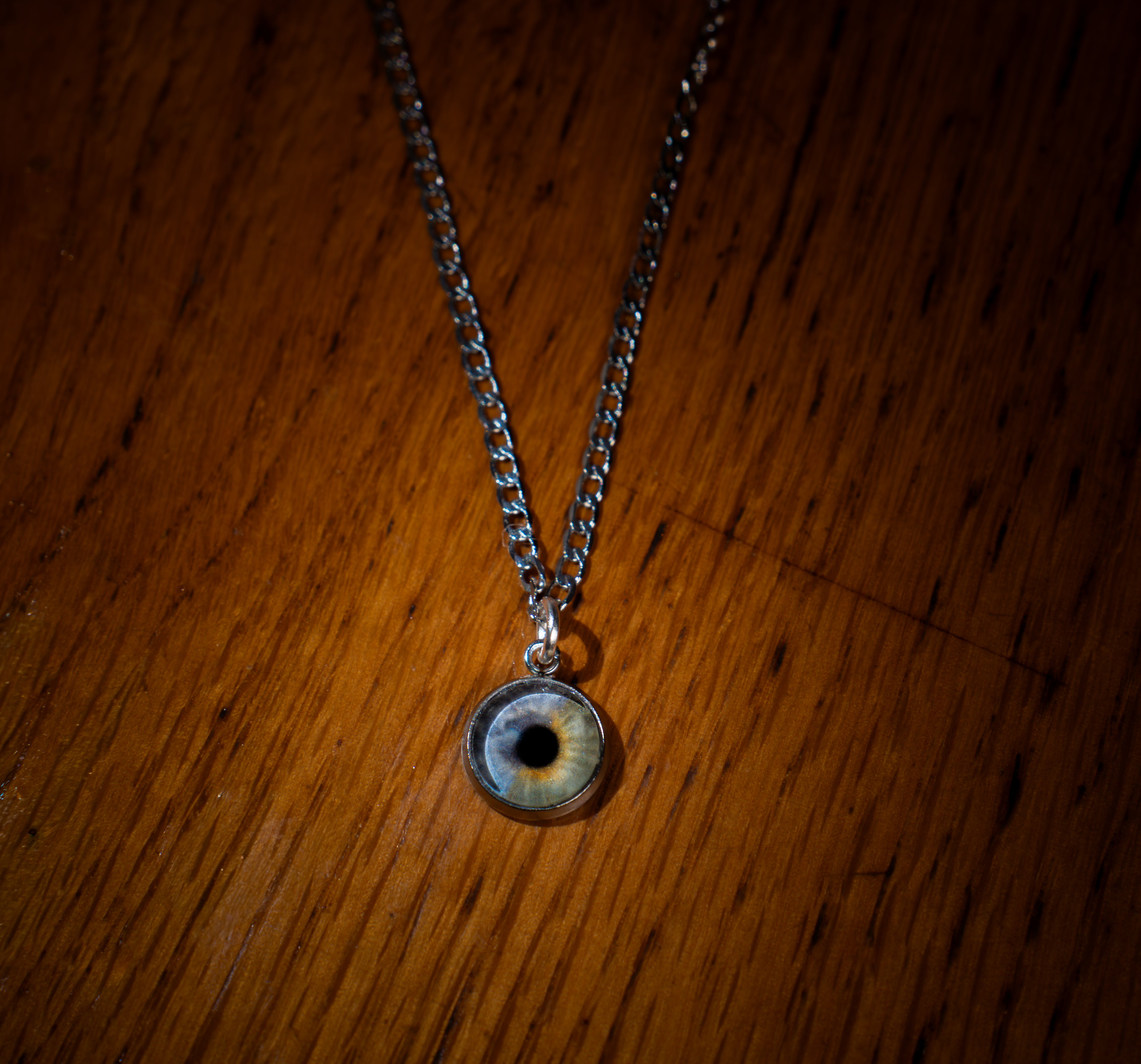 Necklace with an eye-shaped pendant on a wooden surface