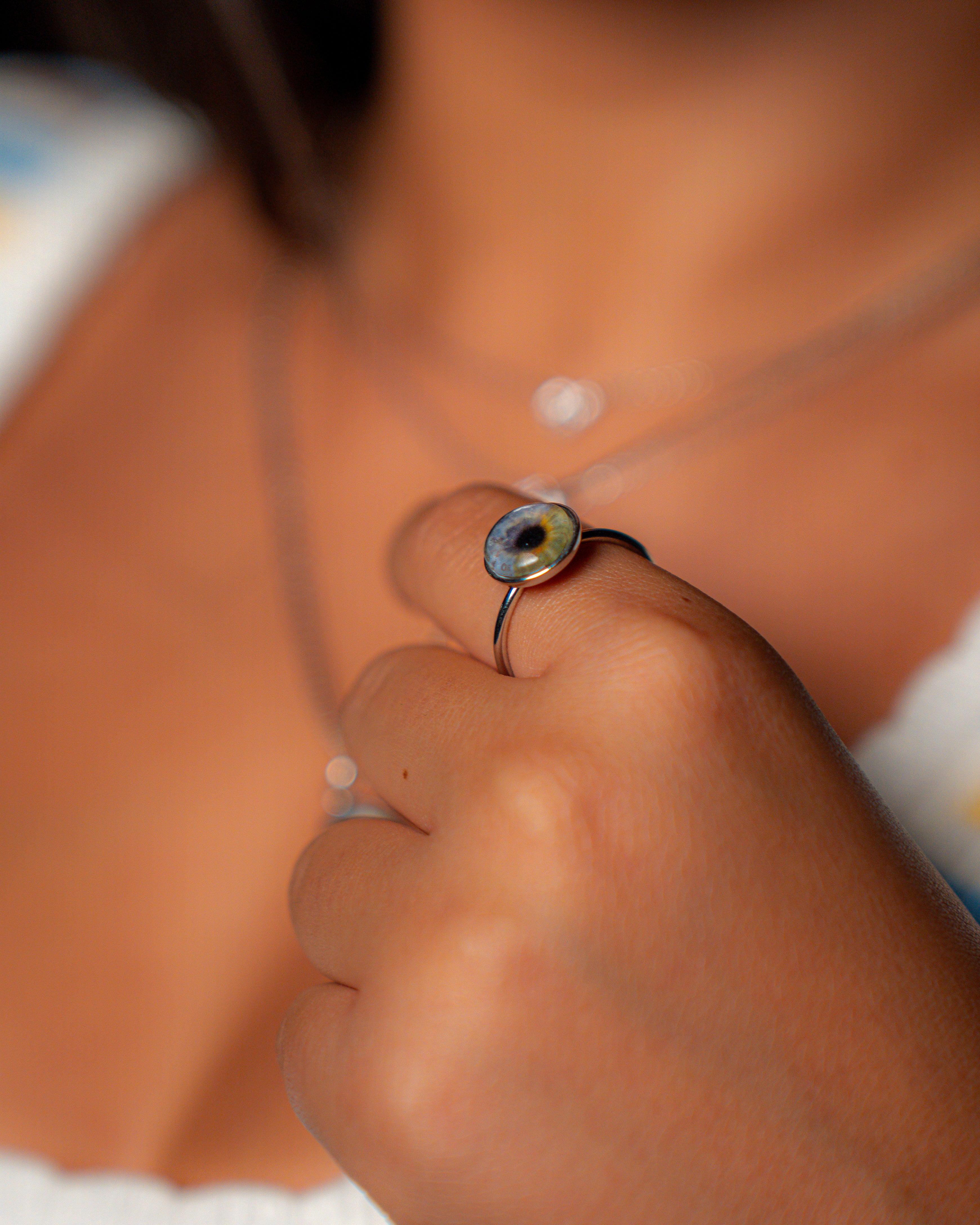 Close-up of a hand wearing a silver ring with a green gemstone.